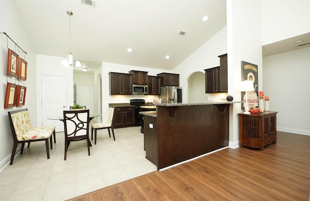 614 Red Fern Rd, Crestview, FL 32536 - kitchen featuring stainless steel appliances, dark brown cabinets, light stone counters, a peninsula, and a kitchen breakfast bar