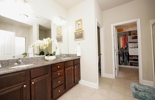 614 Red Fern Rd, Crestview, FL 32536 - full bath with double vanity, a walk in closet, tile patterned floors, and baseboards