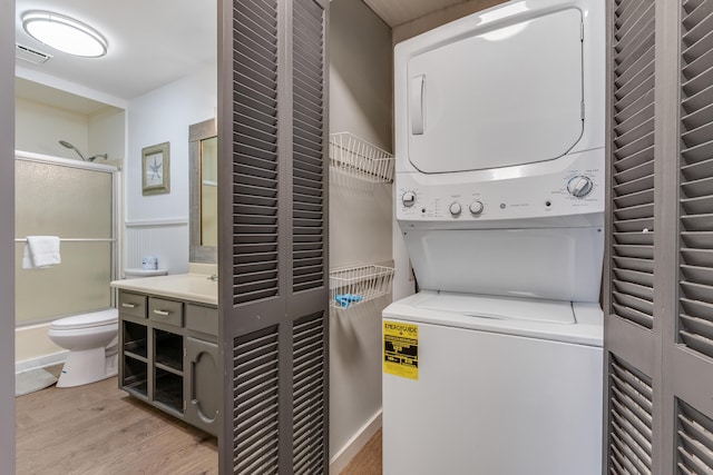 300 Cain Rd Unit 320, Panama City Beach, FL 32413 - laundry area with stacked washing maching and dryer, a wainscoted wall, light wood-style floors, and visible vents