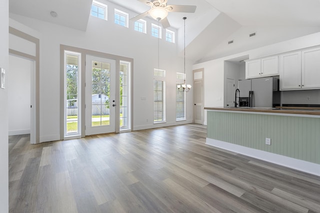1429 N County Highway 393, Santa Rosa Beach, FL 32459 - unfurnished living room with baseboards, light wood finished floors, ceiling fan with notable chandelier, and high vaulted ceiling