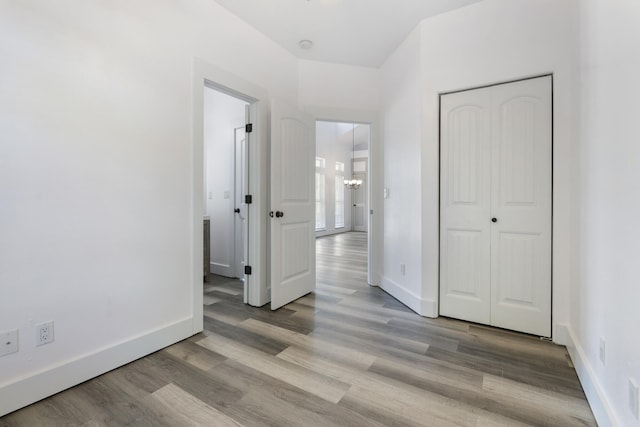 1429 N County Highway 393, Santa Rosa Beach, FL 32459 - unfurnished bedroom featuring a closet, baseboards, wood finished floors, and a chandelier