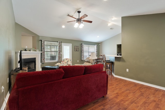 6100 Buck Ward Rd, Baker, FL 32531 - living area featuring wood finished floors, lofted ceiling, a fireplace, baseboards, and ceiling fan