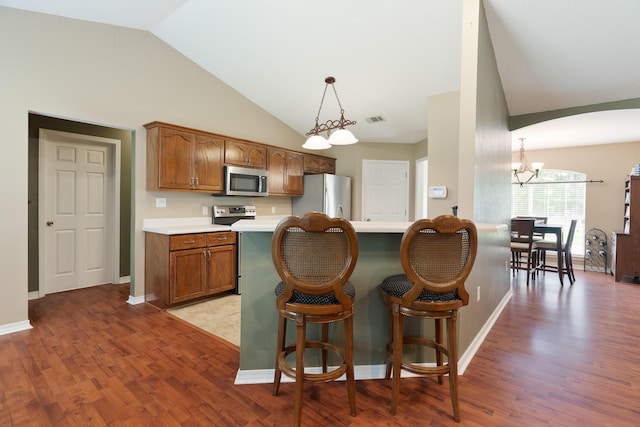 6100 Buck Ward Rd, Baker, FL 32531 - kitchen featuring a notable chandelier, appliances with stainless steel finishes, brown cabinetry, light wood-type flooring, and visible vents