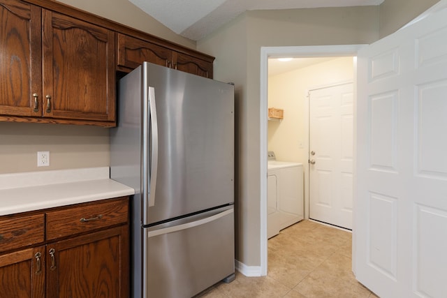 6100 Buck Ward Rd, Baker, FL 32531 - kitchen featuring light tile patterned floors, baseboards, light countertops, freestanding refrigerator, and separate washer and dryer