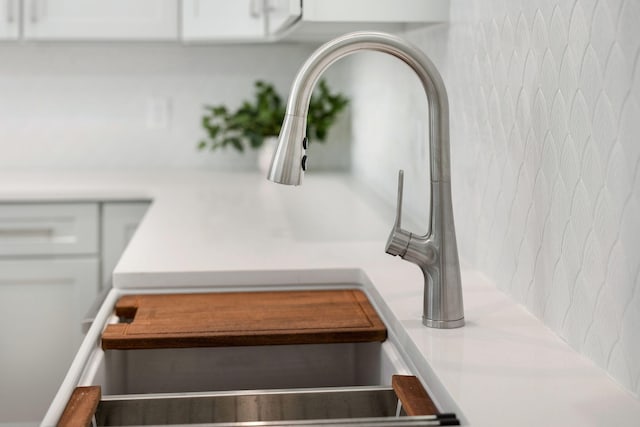 details featuring a sink, light countertops, and white cabinets