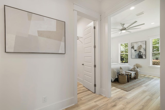corridor with baseboards, recessed lighting, visible vents, and wood finished floors