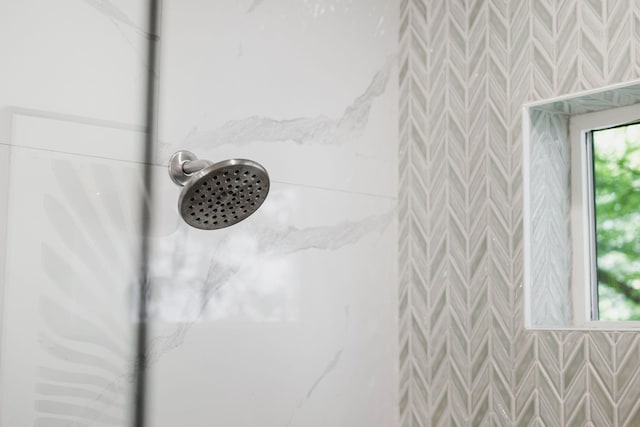 details featuring a shower and wallpapered walls