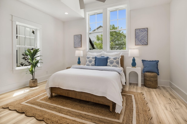 bedroom featuring wood finished floors, baseboards, and recessed lighting