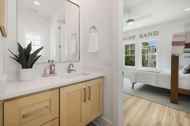 ensuite bathroom featuring a wealth of natural light, ensuite bath, a ceiling fan, and wood finished floors