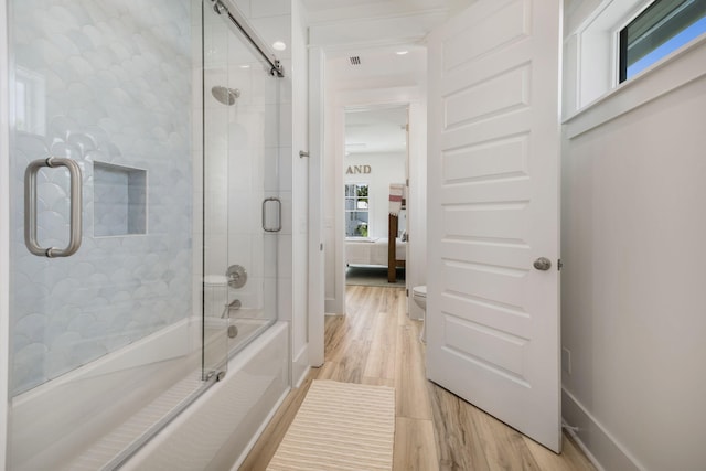 ensuite bathroom with connected bathroom, visible vents, wood finished floors, and shower / bath combination with glass door