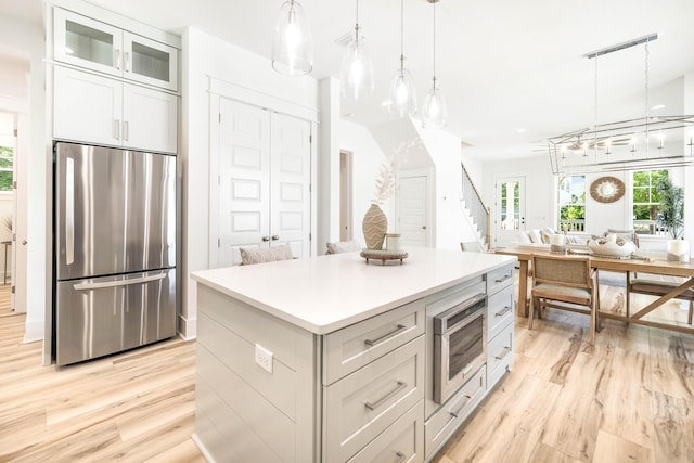 174 Grande Pointe Cir, Inlet Beach, FL 32461 - kitchen with appliances with stainless steel finishes, light wood finished floors, a kitchen island, pendant lighting, and light countertops