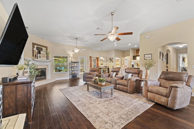 living area with ceiling fan, arched walkways, recessed lighting, dark wood-type flooring, and visible vents