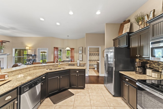 kitchen with recessed lighting, light stone counters, a sink, appliances with stainless steel finishes, and light tile patterned floors