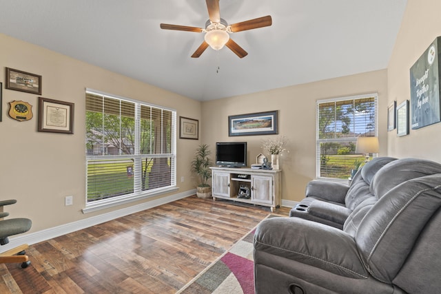 living area with baseboards, ceiling fan, and wood finished floors