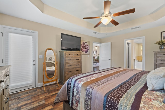 bedroom featuring visible vents, a ceiling fan, dark wood finished floors, and a tray ceiling