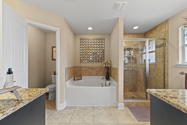 bathroom featuring toilet, tile patterned floors, a bath, and a stall shower