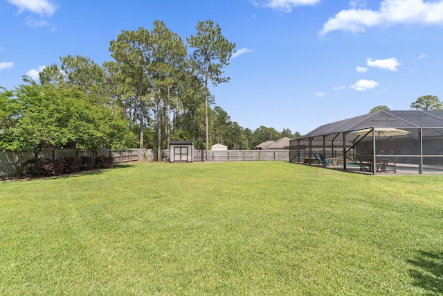 view of yard with a shed, a fenced backyard, a fenced in pool, an outdoor structure, and glass enclosure