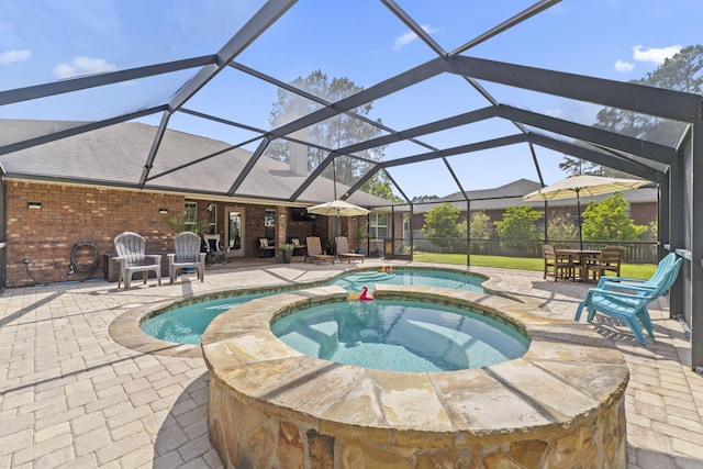 view of swimming pool featuring a lanai, a patio area, and a pool with connected hot tub