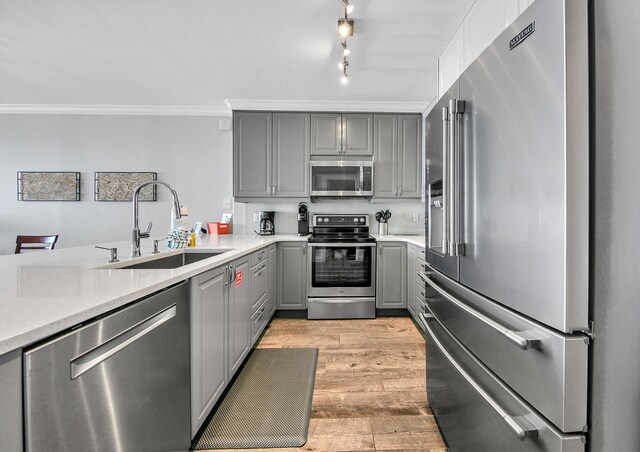 10519 Front Beach Rd Unit 1802B, Panama City Beach, FL 32407 - kitchen with a sink, light wood-style floors, light countertops, gray cabinets, and stainless steel appliances