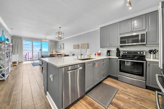 10519 Front Beach Rd Unit 1802B, Panama City Beach, FL 32407 - kitchen with a sink, appliances with stainless steel finishes, ornamental molding, and gray cabinets
