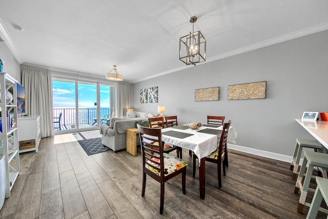 10519 Front Beach Rd Unit 1802B, Panama City Beach, FL 32407 - dining area with baseboards, ornamental molding, wood finished floors, and a chandelier