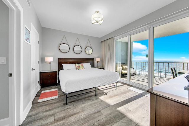 10519 Front Beach Rd Unit 1802B, Panama City Beach, FL 32407 - bedroom featuring access to exterior, baseboards, wood finished floors, a water view, and visible vents