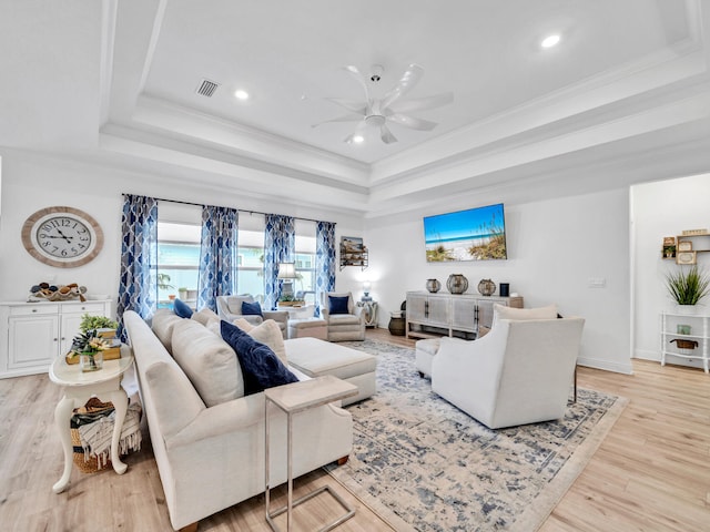 183 Pine Lake Dr, Santa Rosa Beach, FL 32459 - living room featuring visible vents, ornamental molding, a tray ceiling, a ceiling fan, and light wood-style flooring