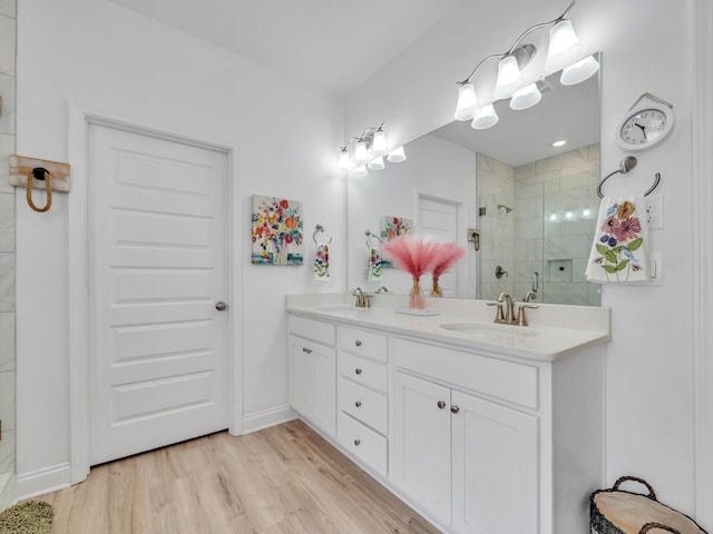 183 Pine Lake Dr, Santa Rosa Beach, FL 32459 - bathroom with a sink, double vanity, a stall shower, and wood finished floors