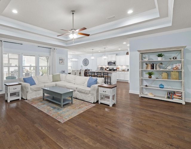 672 Alderberry Rd, Santa Rosa Beach, FL 32459 - living area with ceiling fan with notable chandelier, crown molding, a tray ceiling, and dark wood-style floors