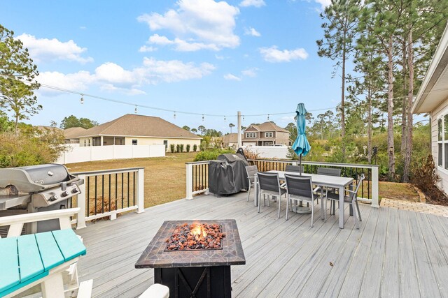 672 Alderberry Rd, Santa Rosa Beach, FL 32459 - wooden deck featuring fence, area for grilling, outdoor dining area, a yard, and a fire pit