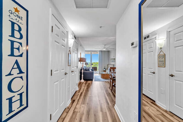 hallway featuring visible vents and light wood-style flooring