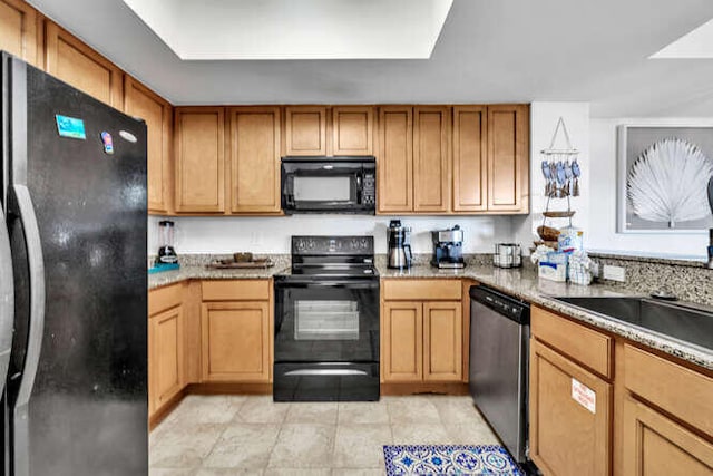 kitchen featuring light tile patterned flooring and black appliances