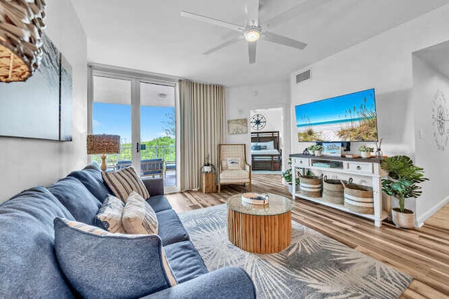 living area with ceiling fan, french doors, wood finished floors, and visible vents