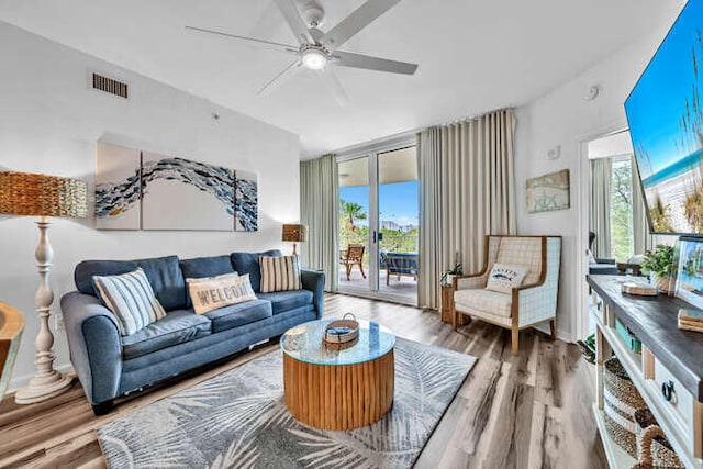 living area featuring ceiling fan, visible vents, and wood finished floors