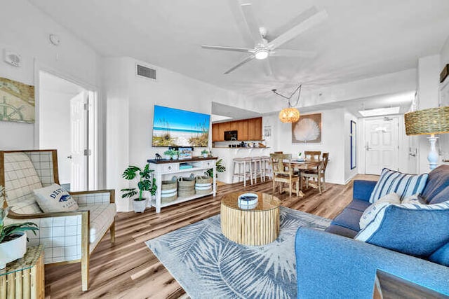 living area featuring ceiling fan, visible vents, and light wood-style floors