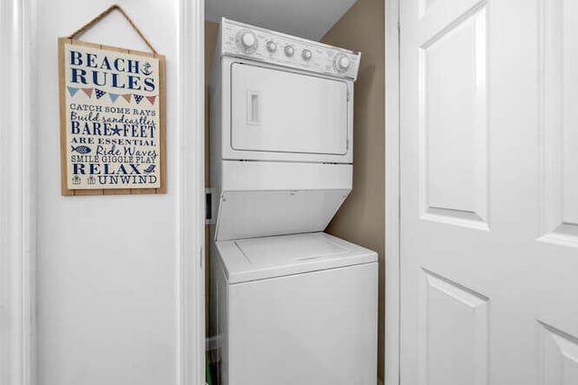 clothes washing area with laundry area and stacked washer / drying machine