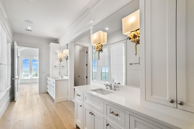 full bathroom featuring recessed lighting, a sink, two vanities, and hardwood / wood-style floors