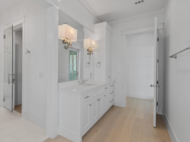full bath with vanity, baseboards, wood finished floors, and visible vents