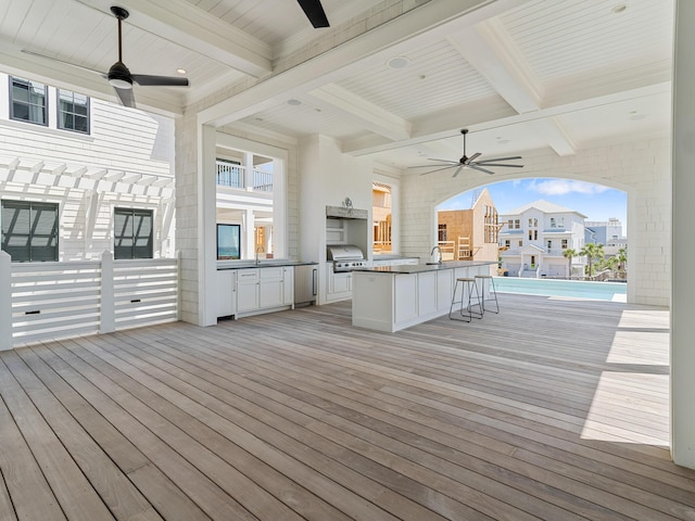 wooden deck with ceiling fan, a sink, exterior kitchen, and grilling area