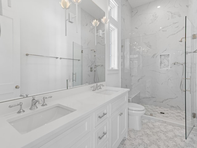 bathroom featuring double vanity, a sink, a marble finish shower, and toilet