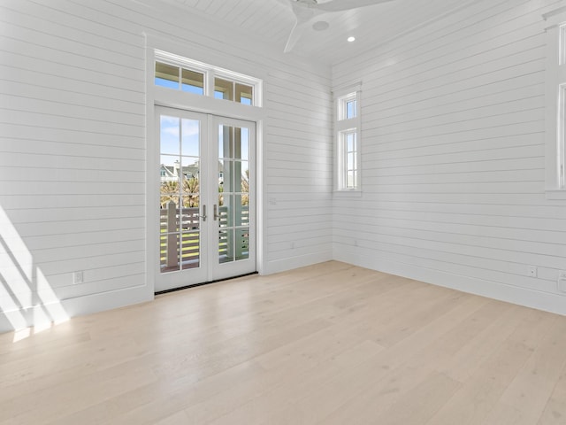 empty room featuring wood walls, recessed lighting, french doors, a ceiling fan, and light wood finished floors