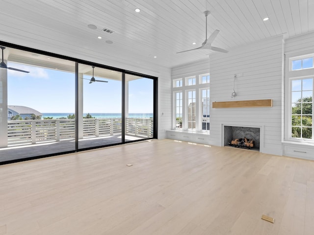 unfurnished living room featuring a ceiling fan, wood finished floors, and wooden ceiling