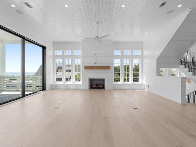 unfurnished living room with ceiling fan, a fireplace, wooden ceiling, wood finished floors, and visible vents