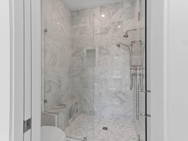 bathroom featuring a stall shower and toilet