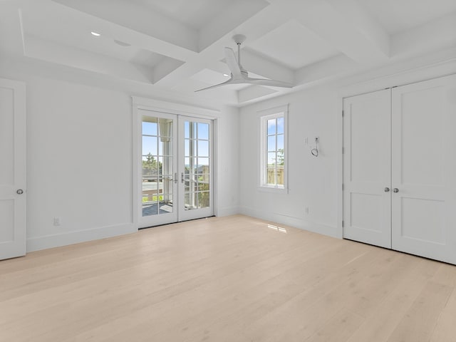 empty room featuring baseboards, ceiling fan, light wood-style flooring, and coffered ceiling
