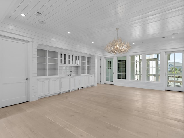 unfurnished living room featuring an inviting chandelier, recessed lighting, light wood-type flooring, wood ceiling, and a sink