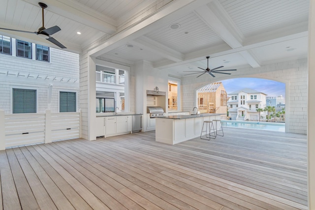 interior space with a ceiling fan, a sink, and area for grilling