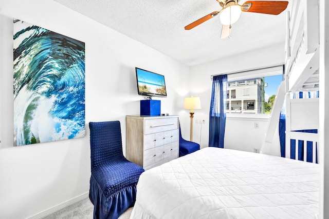 bedroom featuring baseboards, carpet floors, ceiling fan, and a textured ceiling