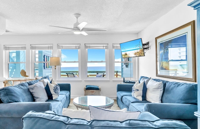 living room featuring a textured ceiling, baseboards, and a ceiling fan