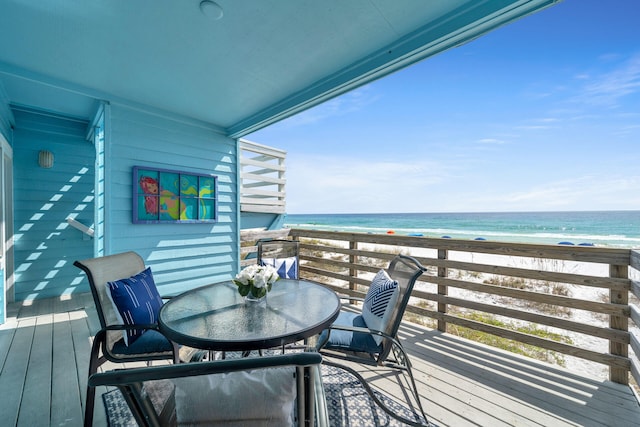 balcony with a water view and a view of the beach